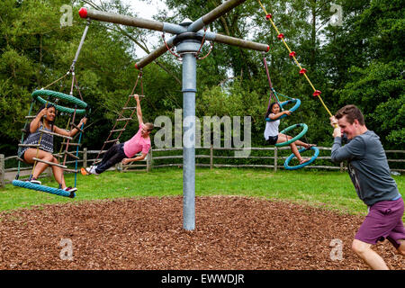 Eine Familie spielen auf Schaukeln, Play Area, Sussex, Großbritannien Stockfoto