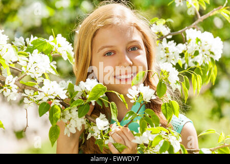 Lächelnde Teenager-Mädchen mit Blumen auf Birnbaum Stockfoto