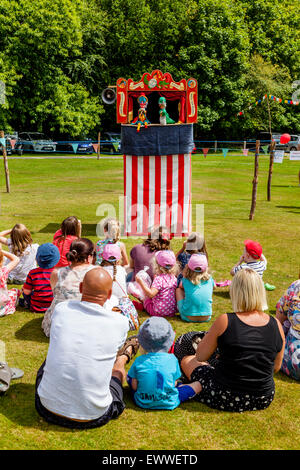 Einheimische Kinder beobachten ein traditioneller Punch & Judy Show im jährlichen Nutley Dorffest, Nutley, Sussex, UK Stockfoto