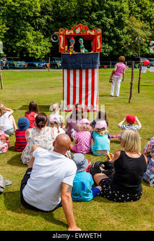 Einheimische Kinder beobachten ein traditioneller Punch & Judy Show im jährlichen Nutley Dorffest, Nutley, Sussex, UK Stockfoto