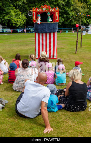 Einheimische Kinder beobachten ein traditioneller Punch & Judy Show im jährlichen Nutley Dorffest, Nutley, Sussex, UK Stockfoto