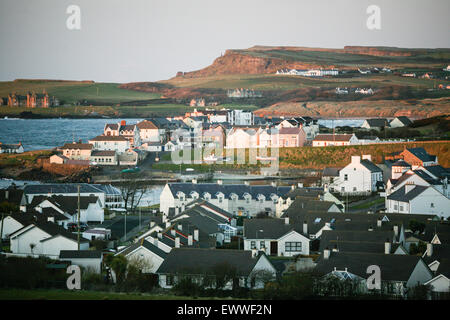 Untergehende Sonne und Stadt von Portrush, im County Londonderry, Nordirland.  Foto von der A2 Straße spektakuläre Küsten Stockfoto