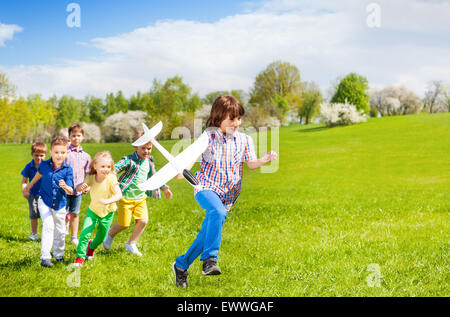 Happy laufen Kinder mit großen weißen Flugzeug Spielzeug Stockfoto