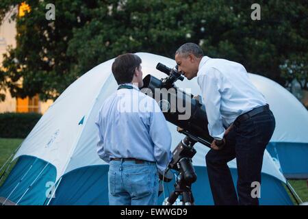 US-Präsident Barack Obama sieht durch ein Teleskop während der allerersten weiße Haus Feldlagers mit fünfzig-vierten Klasse Mädchen als Bestandteil der gehen! Außen-Initiative auf dem South Lawn des weißen Hauses 30. Juni 2015 in Washington, DC. Neben den Feldlagers genossen die Mädchen Sternguckerei Aktivität mit Wissenschaftlern und Astronaut Cady Coleman. Stockfoto