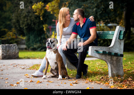 Frauen sitzen im Freien mit ihrem Haustier Hund Deutschen Boxer Stockfoto