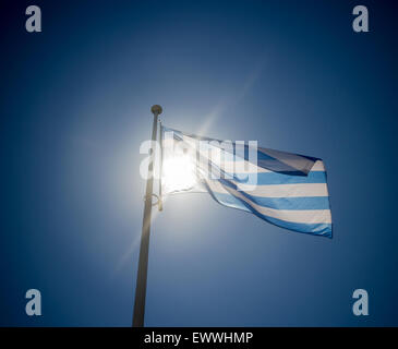 Griechische Flagge winken vor Sonne am blauen Himmel, Contre-Jour-Hintergrundbeleuchtung Stockfoto