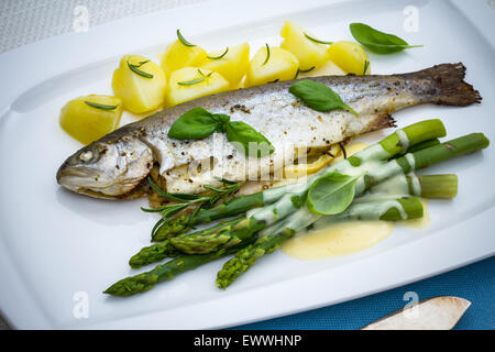 Gegrillte Forelle mit grünem Spargel und Rosmarinkartoffeln, Ansicht von oben Stockfoto