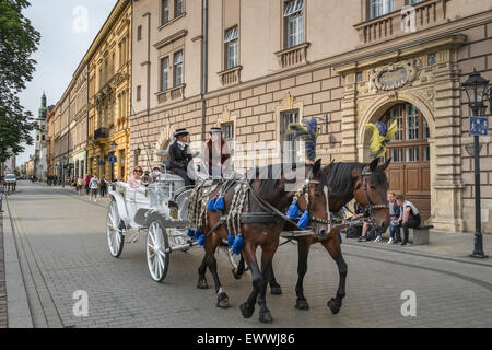 Touristen, wobei traditionelle Pferd und Kutsche fahren Sie durch die alte Stadt von Krakau, Polen. Stockfoto