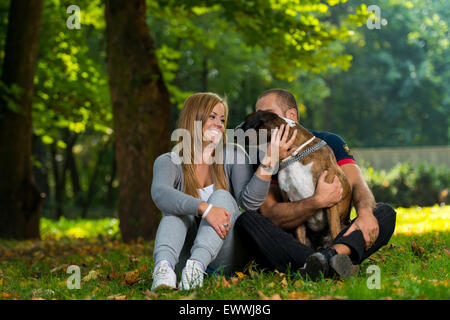 Frauen sitzen im Freien mit ihrem Haustier Hund Deutschen Boxer Stockfoto