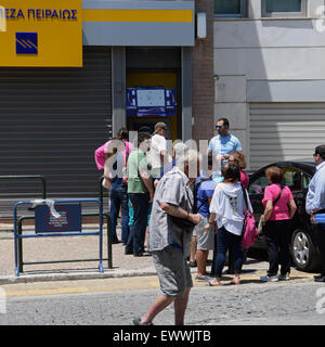 Schlange von Menschen Geld aus Geldautomaten vor einer geschlossenen Bank warten, nachdem Kapitalkontrollen umgesetzt wurden. Athen, Griechenland. Stockfoto