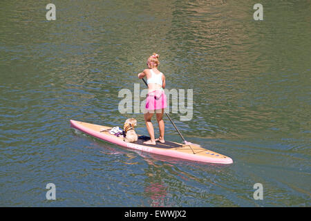 Eine Frau Paddling auf der Deschutes River in Oregon mit ihrem Hund als Beifahrer. Stockfoto