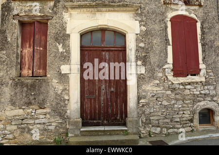 Die Tür und Fassade eines ehemaligen Weinguts in Corconne, Frankreich. Die Anlage ist nicht mehr gebräuchlich. Stockfoto