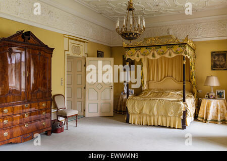 Himmelbett mit vergoldeten Rahmen in üppig Schlafzimmer mit Stuckdecke und antiker Schrank Stockfoto