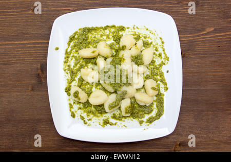 Gnocchi mit Basilikum-Pesto auf Holztisch von oben gesehen Stockfoto