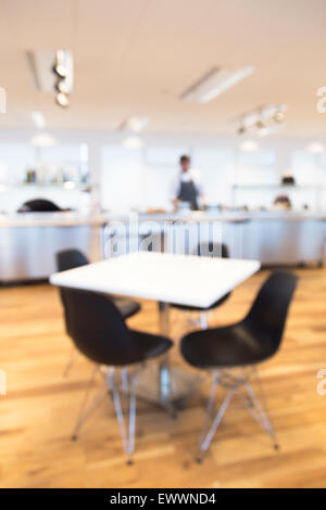 Ideal für als aus Fokus Schuss eine Büro-Cafeteria, Chef besucht das Essen an der Theke mit Tisch im Vordergrund, verwenden Stockfoto