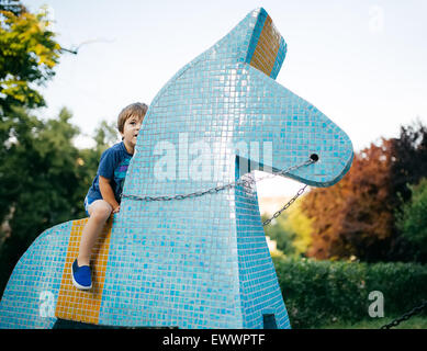 Kleiner Junge reitet Spielzeug Pferd keramischen Fliese Stockfoto