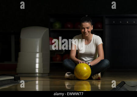 Fröhliche junge Frauen mit Bowling Ball Stockfoto