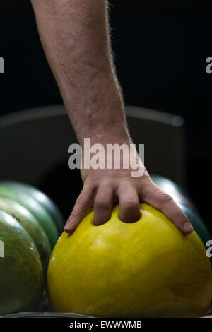 Mann hält eine Bowling-Kugel Stockfoto