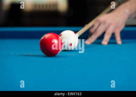 Man spielt Pool rund um den Ball Stockfoto