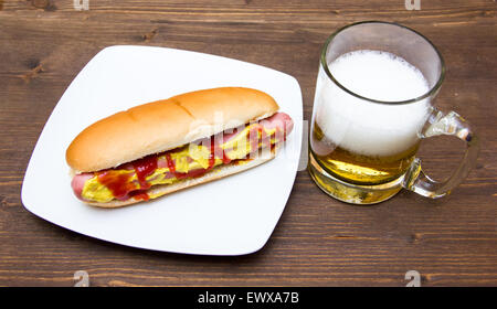 Bier und Hot Dogs auf Holztisch Stockfoto