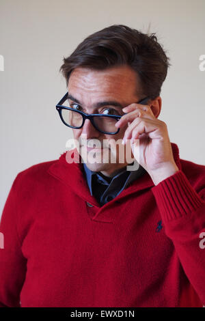 Hübscher Mann mittleren Alters mit Blick auf Gläser Stockfoto