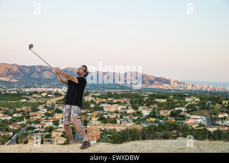 Kerl mit Selfie Stick versuchen, cool aussehen Stockfoto