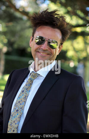 Intelligente Mann mittleren Alters im Business-Anzug und Sonnenbrille mit Haaren im Wind wehen Stockfoto