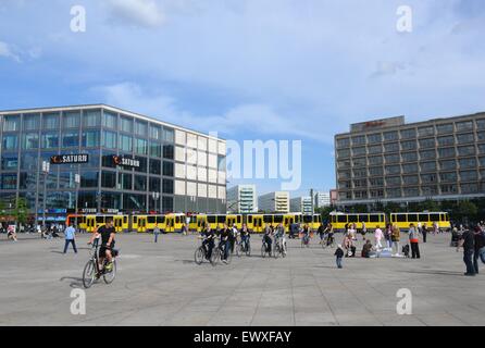 Alexanderplatz, Berlin, Deutschland mit gelben Straßenbahnen, Radfahrern und Fußgängern. Stockfoto
