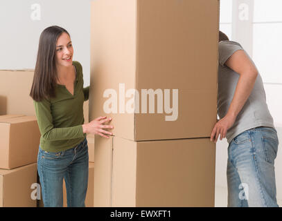 junges Paar spielen verstecken und suchen rund um Kartons bei Umzug Stockfoto