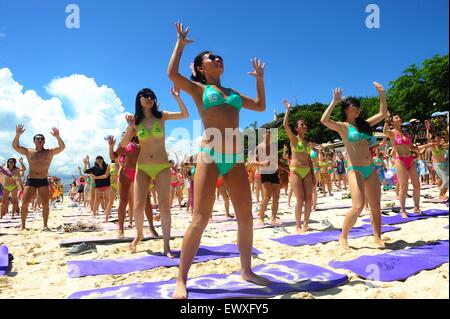 Peking, China. 12. Juli 2014. Foto aufgenommen am 12. Juli 2014 zeigt Yoga-begeisterte praktizieren Yoga im Bikini am Strand von Sanya, Hainan Provinz Süd-China. © Chen 北方文物/Xinhua/Alamy Live-Nachrichten Stockfoto