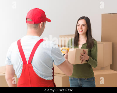 glückliche junge Frau, die ein Paket per Kurier erhalten Stockfoto