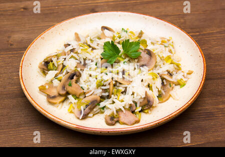 Pilz-Risotto auf dem Teller auf Holztisch Stockfoto