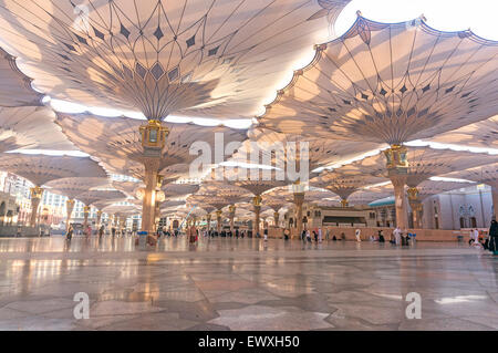 MEDINA, Saudi-Arabien - 6. März 2015: Pilger Fuß unter Riesenschirme auf Nabawi Moschee-Gelände. Stockfoto