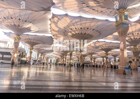 MEDINA, Saudi-Arabien - 6. März 2015: Pilger Fuß unter Riesenschirme auf Nabawi Moschee-Gelände. Stockfoto