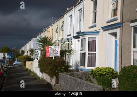 Terrassenförmig angelegten Gehäuse mit der Vermietung Zeichen in Falmouth, Cornwall, England, UK mit Gewitterwolken overhead Stockfoto