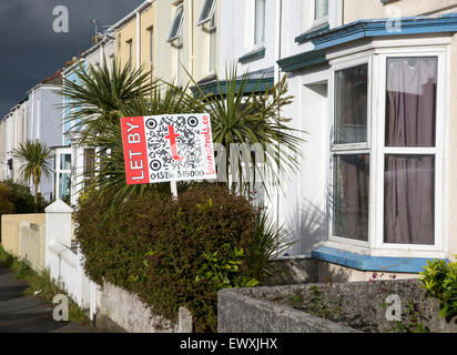 Terrassenförmig angelegten Gehäuse mit der Vermietung Zeichen in Falmouth, Cornwall, England, UK mit Gewitterwolken overhead Stockfoto