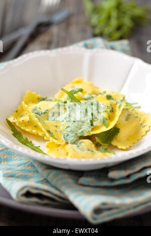 Leckere Ravioli mit Rucola Blätter und Sahne auf rustikalen Holztisch. Stockfoto
