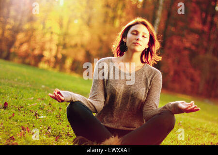 junges Mädchen meditieren im Herbst park Stockfoto