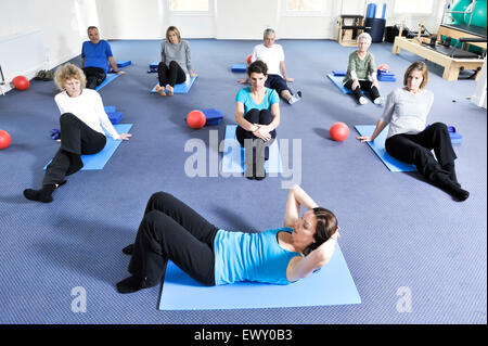 Junge Frau, die Teilnahme an einer Pilates-Klasse. Stockfoto