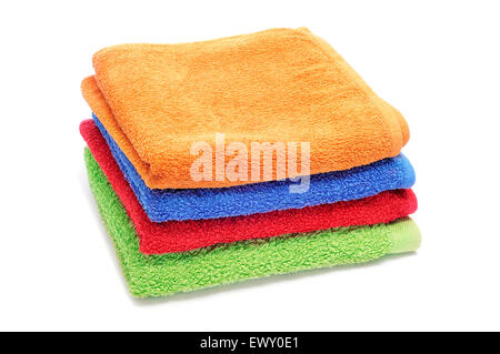 einen Stapel Handtücher in verschiedenen Farben auf weißem Hintergrund Stockfoto