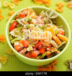 Nahaufnahme einer Schüssel mit erfrischender Nudelsalat auf einem drapierten Tisch mit einer grünen Tischdecke Stockfoto