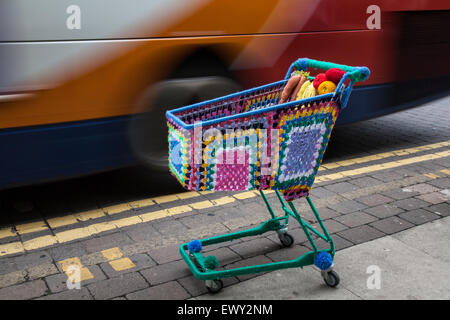 Garnbomben, Bomben, yarnbombing, farbenfrohe dekorative Strickwaren, Co-op Supermarkt-Einkaufswagen, Drahtwagen, Westhearthughton, Lancashire, Großbritannien Stockfoto