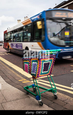 Garnbomben, Bomben, yarnbombing, farbenfrohe dekorative Strickwaren, Co-op Supermarkt-Einkaufswagen, Drahtwagen, Westhearthughton, Lancashire, Großbritannien Stockfoto