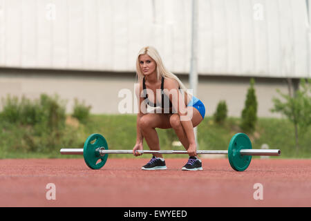 Junge Frau ein Kreuzheben Übung im freien Stockfoto