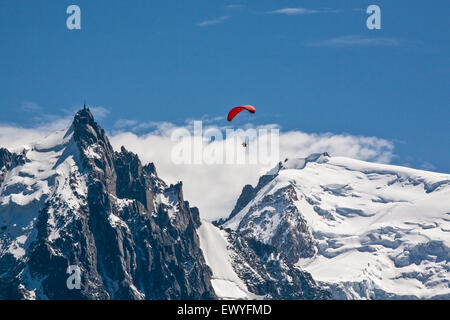 Gleitschirm über dem Tal von Chamonix-Mont-Blanc, Frankreich. Mont Blanc-Massivs Bereich Berg im Hintergrund, mit Aiguille du Midi 3.777 m eines der höchsten Seilbahn Reiseziele der Welt. Stockfoto