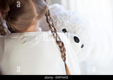 Rückansicht eines Mädchens umarmt ein Teddybär Stockfoto