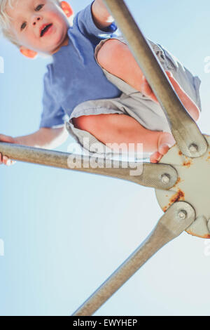 Niedrigen Winkel Blick eines jungen auf einem Klettergerüst auf einem Spielplatz Stockfoto