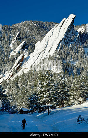 Mann unter Flatirons Wandern bedeckt in Schnee, Boulder Open Space und Mountain Park, Boulder, Colorado USA Stockfoto