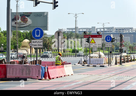 Ausländische Bauarbeiter arbeiten mitten auf der Straße in Dubai, Vereinigte Arabische Emirate Stockfoto