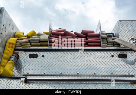 Feuerwehrschläuche am oberen Rand ein Feuerwehrauto. Stockfoto